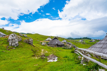 Mountain pastures on Velika Planina (Big Plateau) near city Kamnik in Slovenia alps. Mountain cottage hut or house on idyllic hill with eco farming. Great travel target for family hiking
