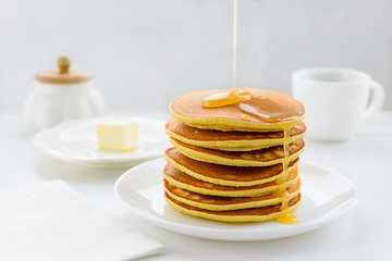 Fototapeta na wymiar Pancakes with honey on a white wooden table