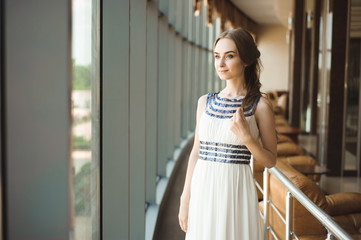 Portrait of a beautiful woman near a large stained-glass window.