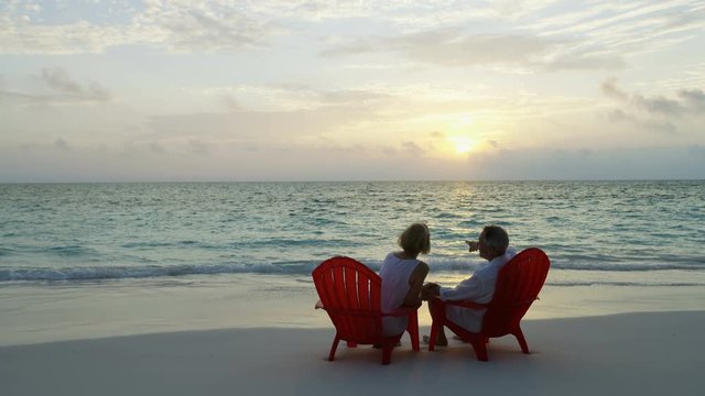Happy Caucasian couple relaxed on beach chairs Caribbean