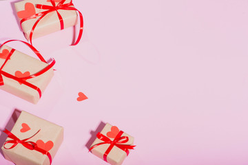 Valentine's Day gift on a pink background lie with a red ribbon hearts with love frame place for text isolate