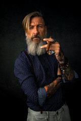 Porträt eines coolen Rockers mit Zigarre in der Hand.	
