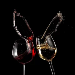 Fotobehang Rode en witte wijnglazen omhoog op zwarte achtergrond © Mariyana M