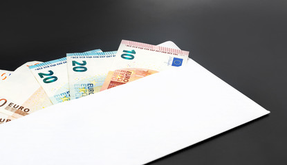 Envelope with euro bills on black.