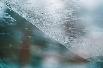 Glass Window Covered With Ice And Rain Drops
