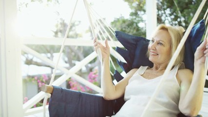 Healthy senior woman relaxing in hammock outdoor Bahamas