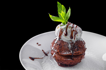 Chocolate fondant with ice cream, on a white plate, with mint and berries