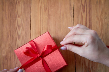 Woman holding a gift box in a gesture of giving.