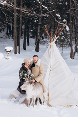 Fototapeta na wymiar Happy wedding couple outdoors in winter beautiful park . Happy emotional and fashionable bride in wedding dress. Emotional, happiness concept