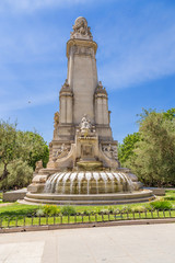 Fototapeta na wymiar Madrid, Spain. The reverse side of the Cervantes memorial: a sculpture of Queen Isabella of Portugal, a fountain with the emblems of Spanish-speaking countries