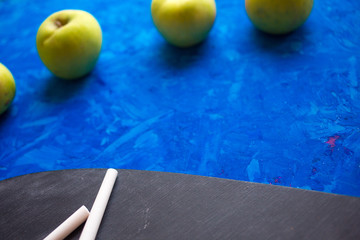 Yellow and green apples on a blue background. School snack
