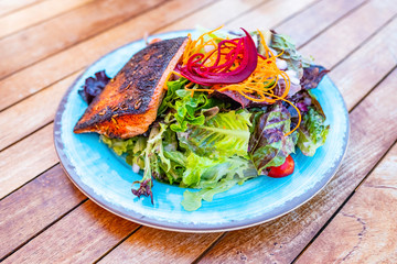 Blackened Salmon and green salad  on blue plate