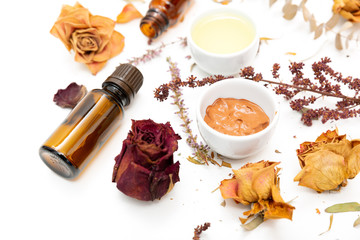 Aromatic botanical cosmetics. Dried herbs flowers mixture, facial mud clay mask, oils, applying brush. Holistic herbal skincare beauty hack