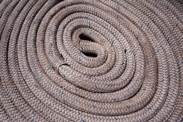 Fototapeta na wymiar Close up of grey nautical rope coiled and with blue highlights