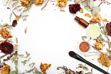 Aromatic botanical cosmetics. Dried herbs flowers mixture, facial mud clay mask, oils, applying brush. Holistic herbal skincare beauty hack