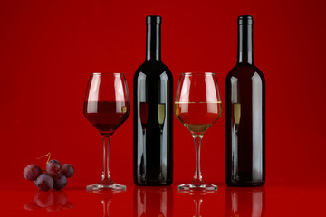 Still life with wine and a bunch of grapes on a Burgundy background
