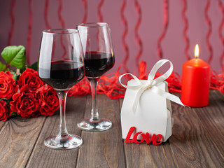 Romantic cozy evening with wine, flowers, candles and present