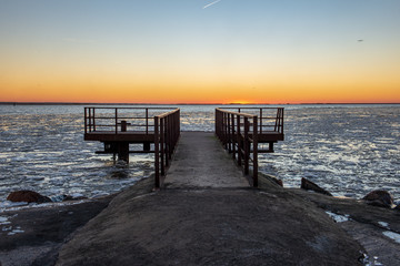 dramatic red sunset over the frozen sea on the beach