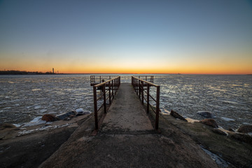 Obraz premium dramatic red sunset over the frozen sea on the beach