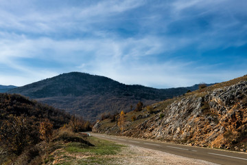 Mountain landscape and road in the autumn cloudy day. Blurred background and soft focus.