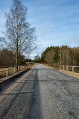 country gravel road with old and broken asphalt