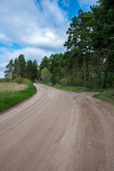 Fototapeta na wymiar country gravel road with old and broken asphalt