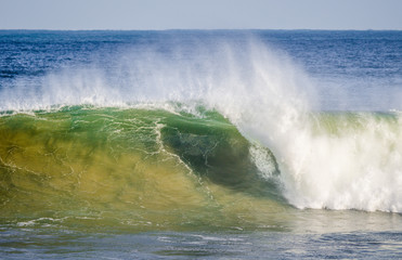 Large breaking wave exploding on the shore