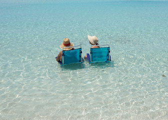 Couple in loungers on a tropical beach at Maldives