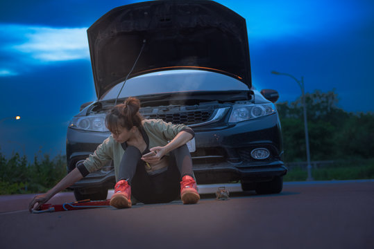 Young Woman In Trouble On The Car Engine Break Down, Engine Over Heat, Waiting For Help And Assistant At Early Of Night Time