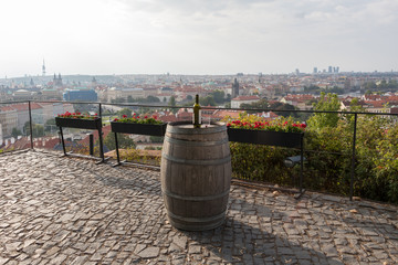 Bottle of red wine with one glass on a barrel in a Prague city, Czech Republic