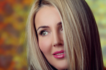 Smiling young woman on yelow wall background.