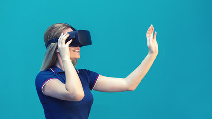 Happy young woman having fun playing on VR glasses