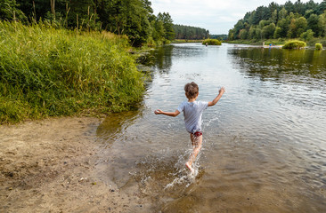 Chłopiec wbiegający do rzeki, wakacje