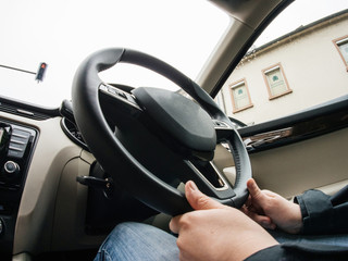 Young woman driving luxury car - view from the interior with ultra-wide lens