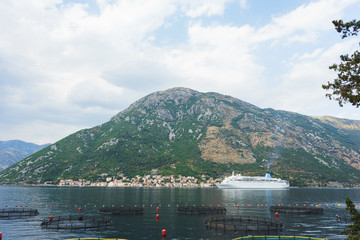 White passenger liner in the bay. Montenegro, Boka Kotorska bay on a hot summer day.