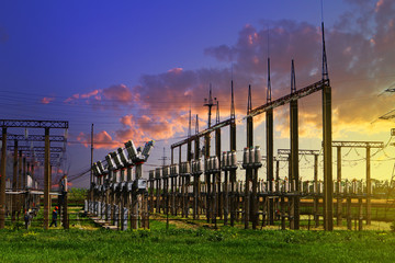 High voltage electric power station - electric poles and lines on blue sunset cloudy sky background