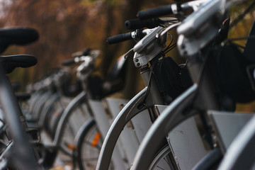 City bike rental: several bicycles ready for hire fixed in the rack.