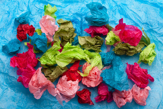 Crumpled colorful tissue paper on a blue tissue paper background 