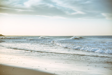 Fototapeta na wymiar Beach photography - blue ocean waves, sand, overcast sky