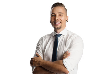Handsome man standing against a white background wearing a white shirt and blue tie, smiling towards camera.
