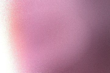 Light shining on rough pink metal wall texture, abstract background