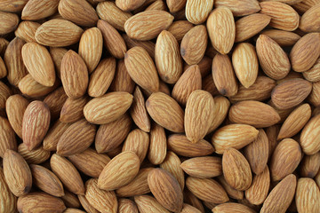 Background of big raw peeled almonds situated arbitrarily