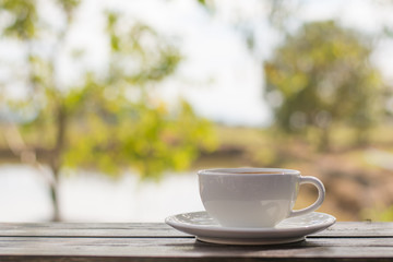 Coffee espresso on wood table nature background in garden,warm tone