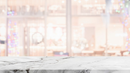 Empty white marble stone table top on blurred with bokeh shopping mall and restaurent interior background - can be used for display or montage your products