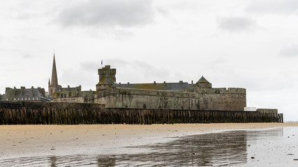 Fototapeta na wymiar Old town of Saint-Malo at low tide on a cloudy day in summer