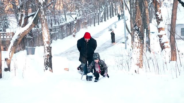 Father and his little children on sled in snow. Children on ski.