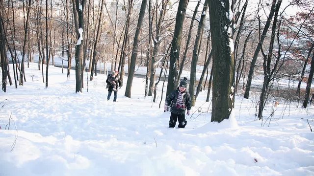 Father and his little children on sled in snow. Children on ski.