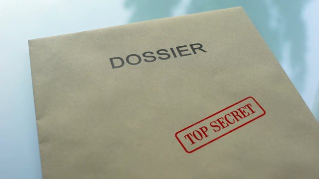 Dossier top secret, hand stamping seal on folder with important documents