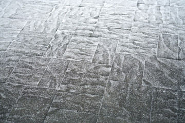 fluffy snow scattering on the concrete ground