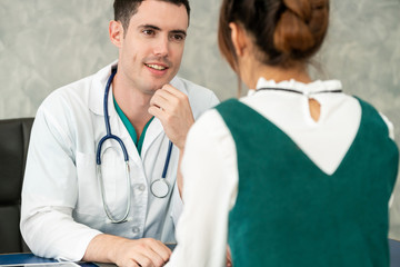 Young doctor examining female patient in hospital office. Medical healthcare and doctor staff...